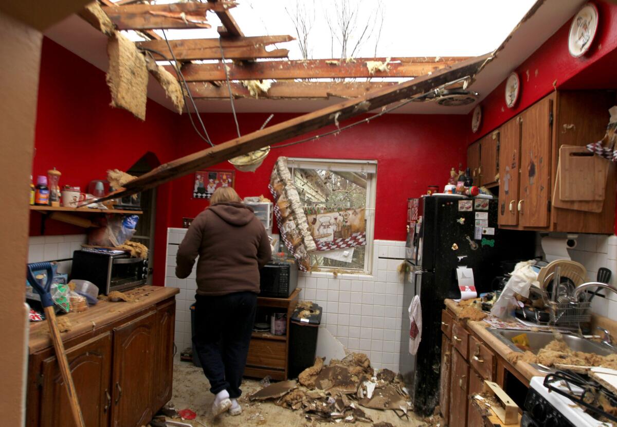 Karla Buneta walks through her storm-damaged kitchen Thursday in Hazelwood, Mo.