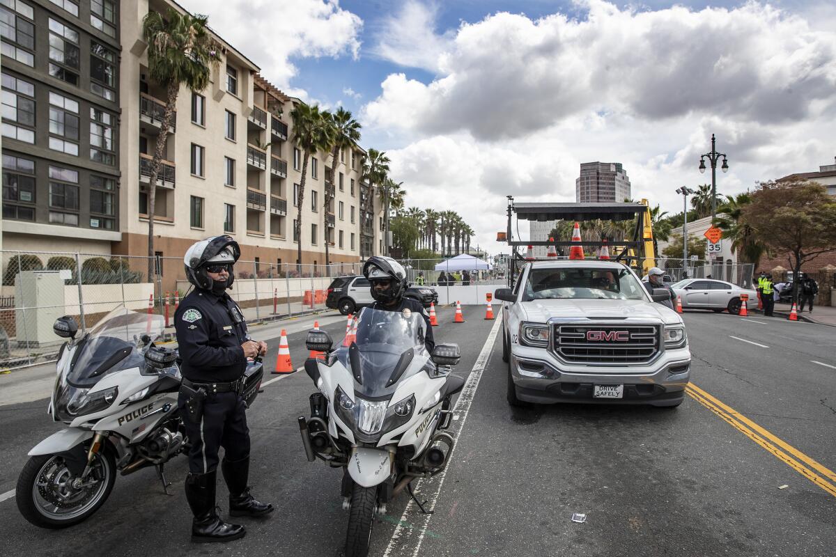 A police officer stands beside department motorcycles.