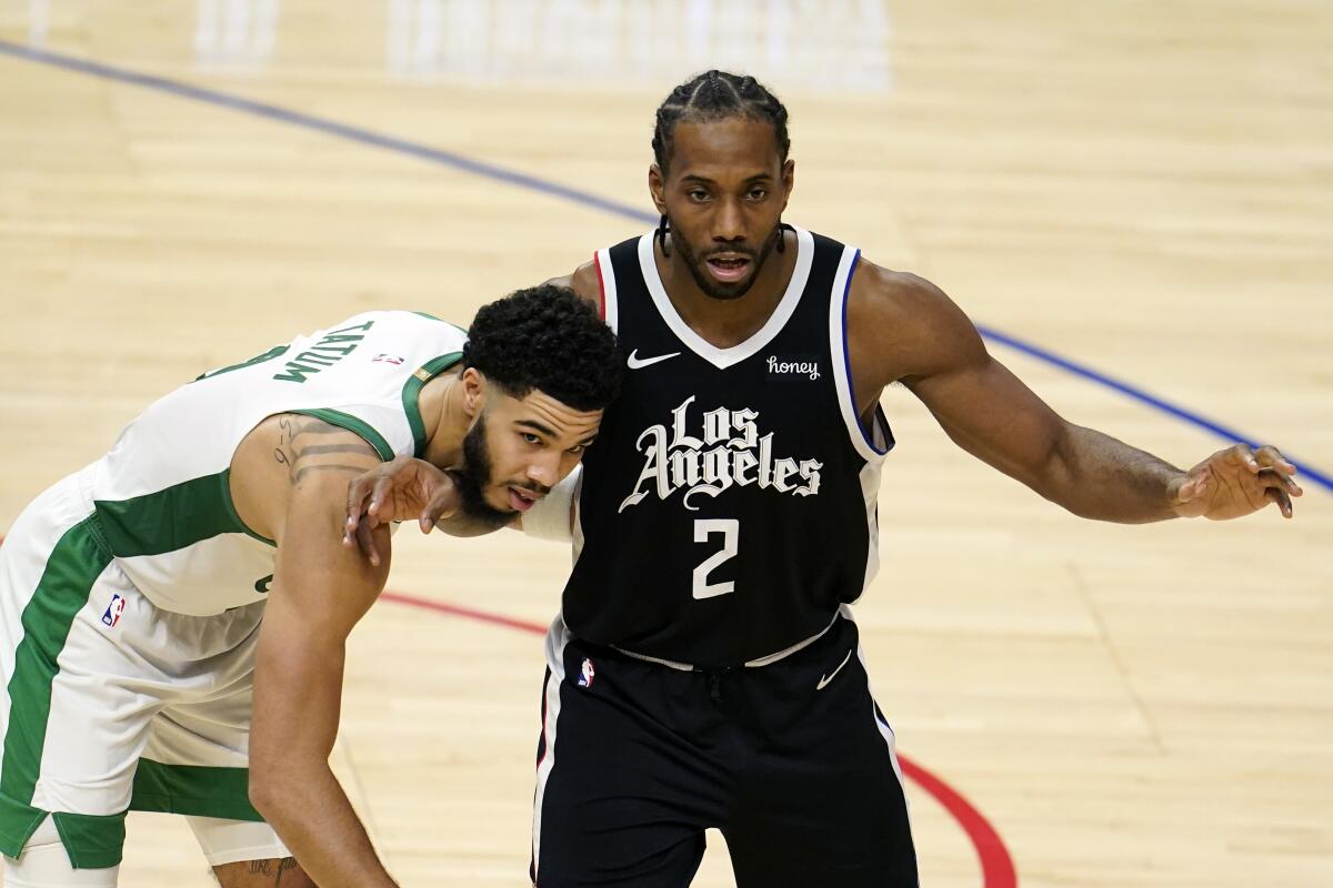 Clippers forward Kawhi Leonard is guarded by Boston Celtics forward Jayson Tatum.