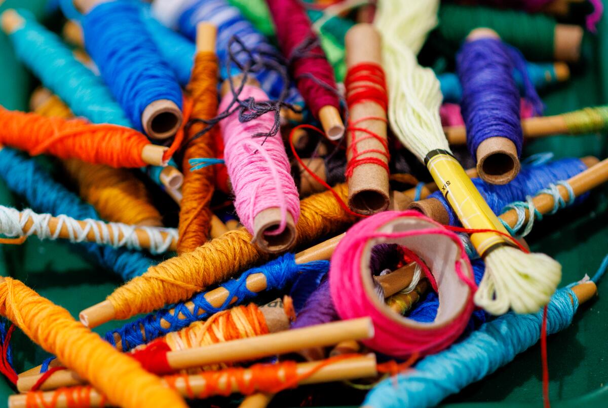 A stack of spools containing several different colors of thread.