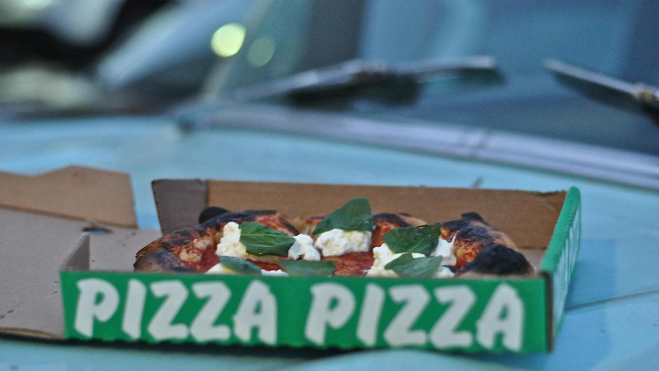 A pizza in a takeout box sits on Vinny Dotolo's 1957 Chevy behind the new Jon & Vinny's on Fairfax Avenue.