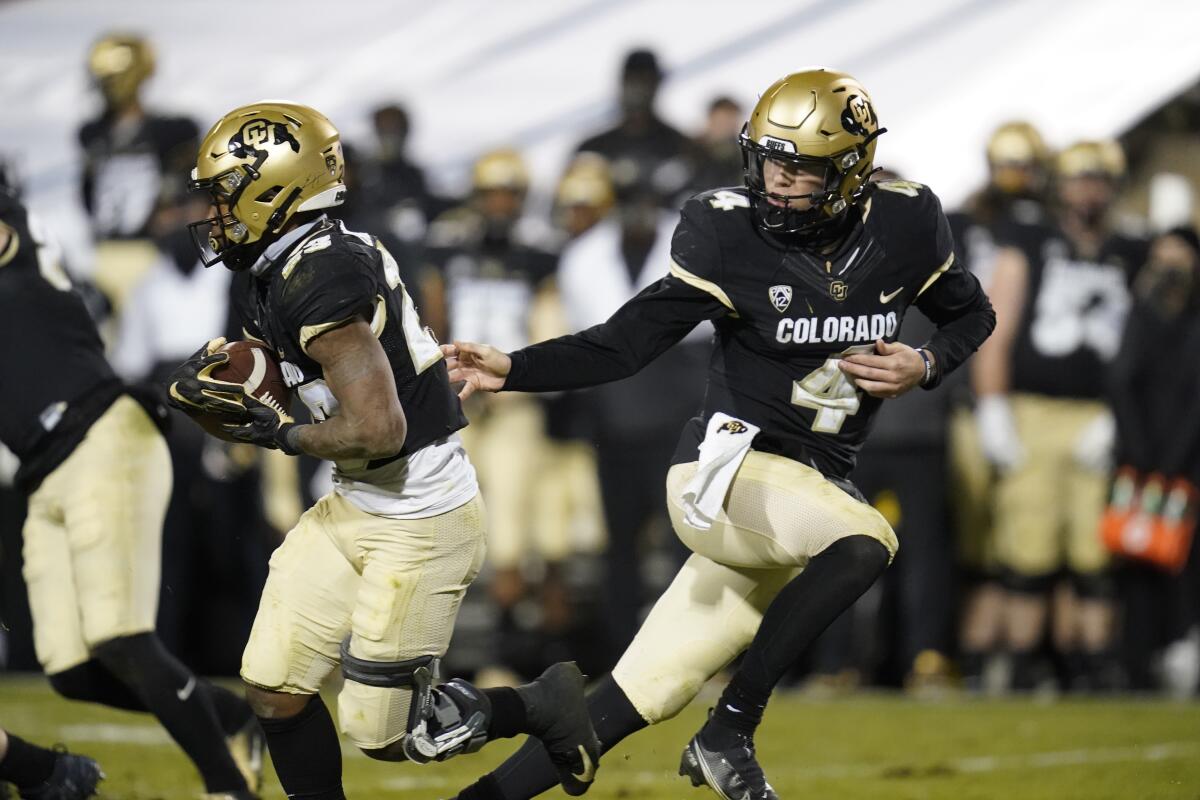 Colorado running back Jarek Broussard takes the handoff from quarterback Sam Noyer.