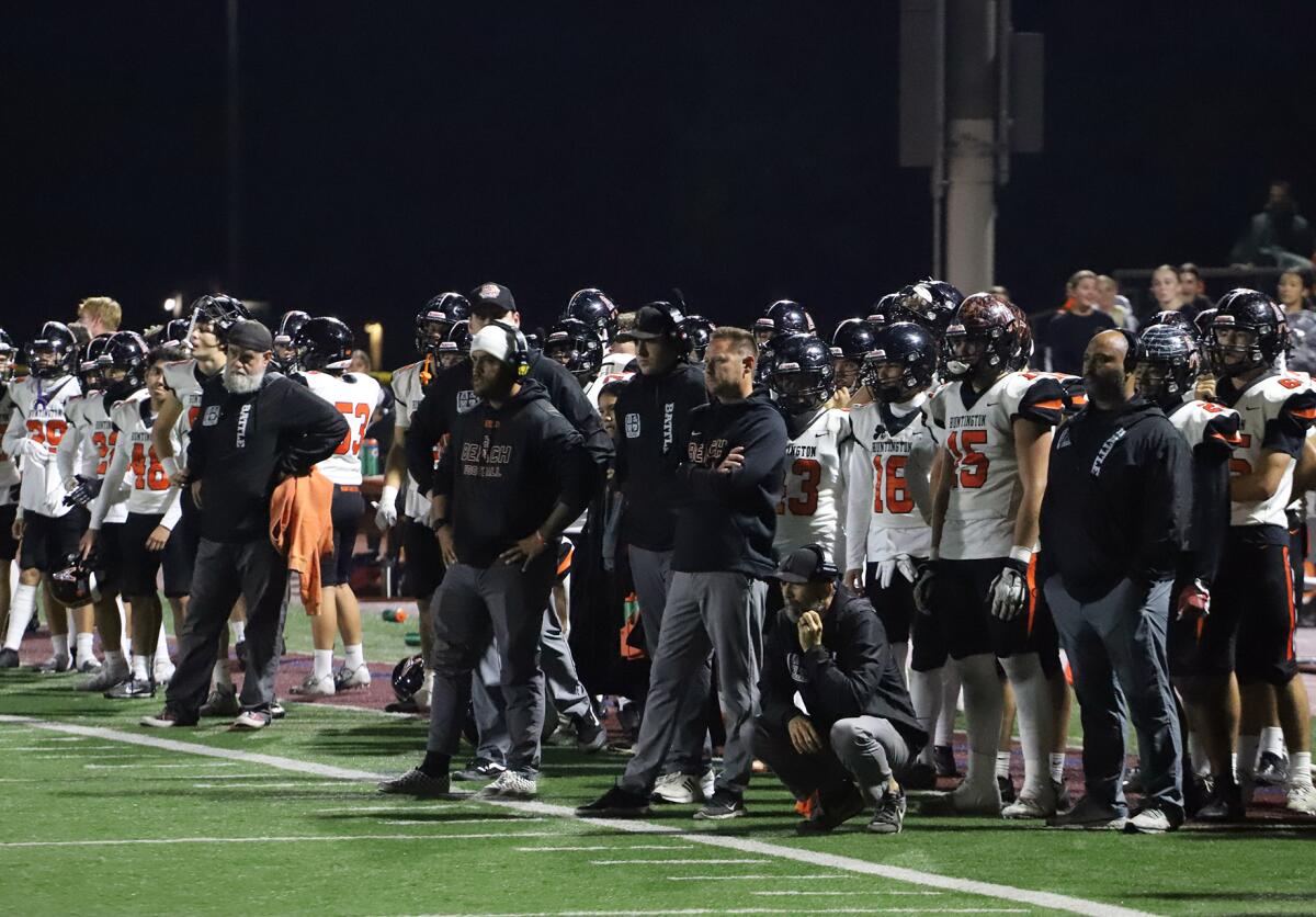 Huntington Beach football coach Brett Brown and the Oilers watch as Simi Valley celebrates its semifinals win on Friday.