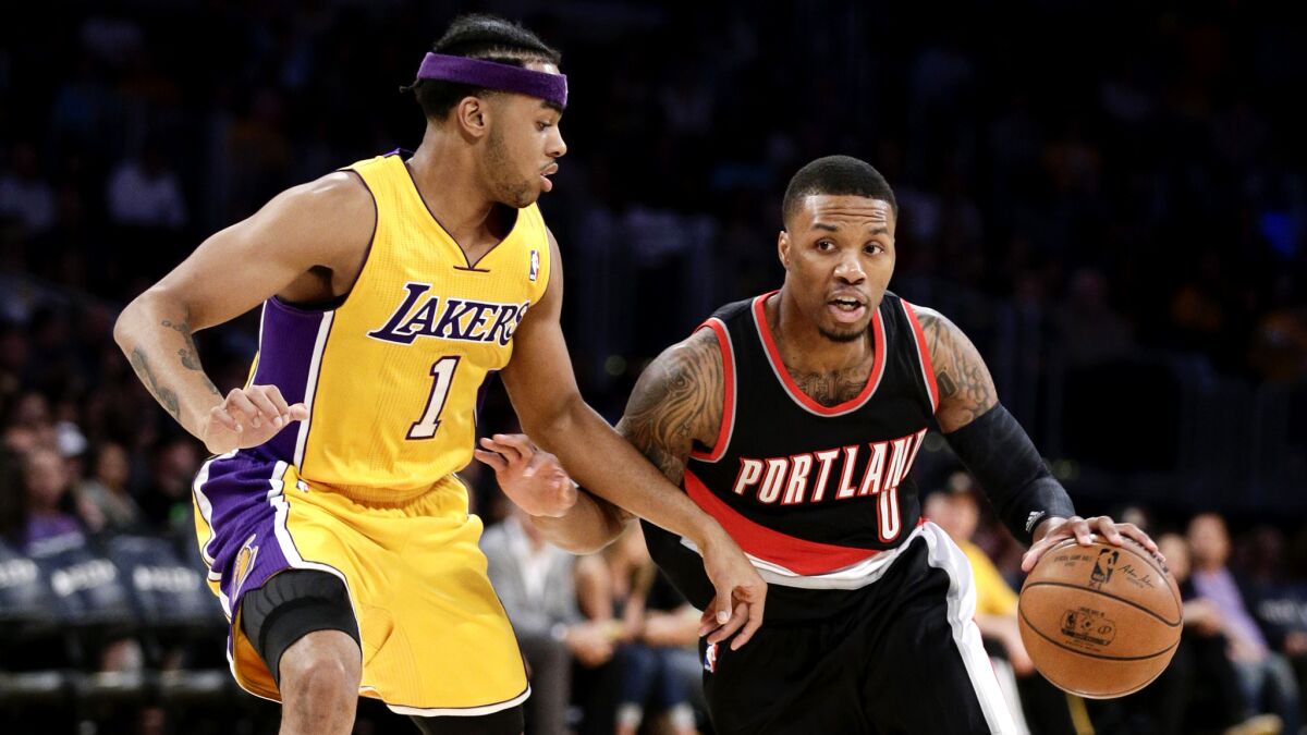 Lakers rookie D'Angelo Russell (1) tries to cut off a drive by Trail Blazers All-Star point guard Damian Lillard during a preseason game.