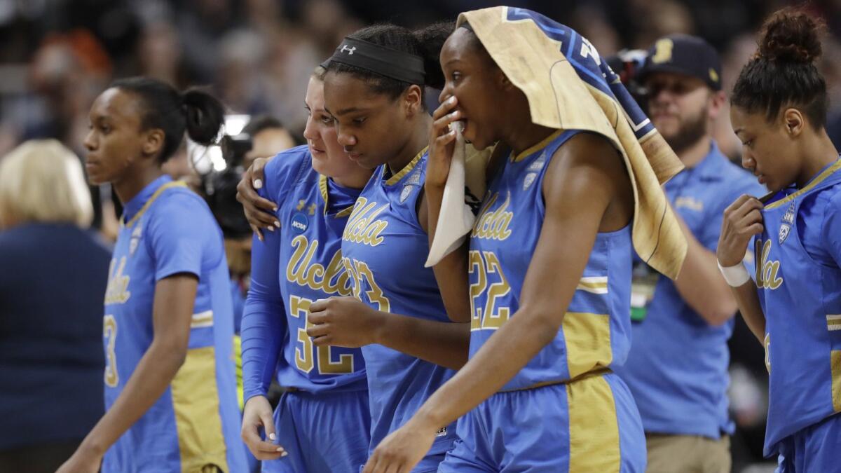 UCLA guard Kiara Jefferson (3), guard Chrissy Baird (32), forward Lauryn Miller (33) and guard Kennedy Burke (22) leave the court after losing to Connecticut.
