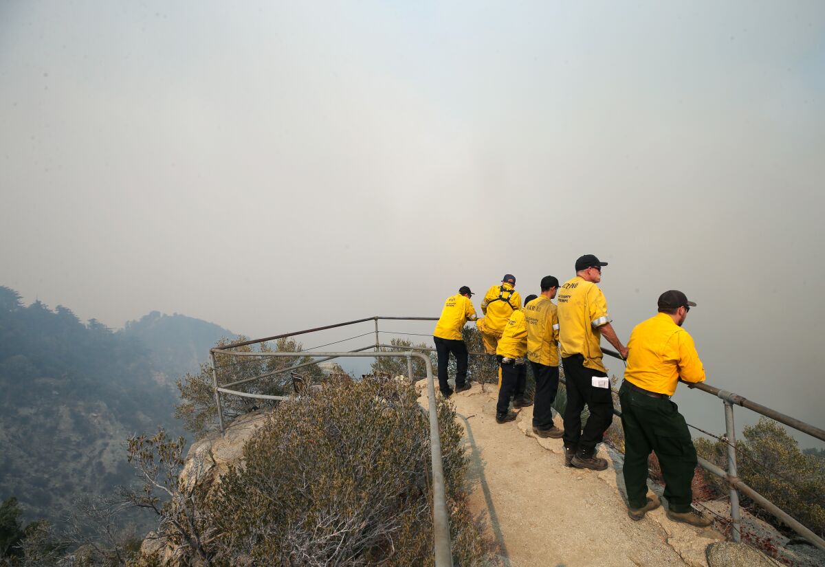 Firefighters keep watch from an overlook on Mount Wilson as the Bobcat Fire burns in the Angeles National Forest.