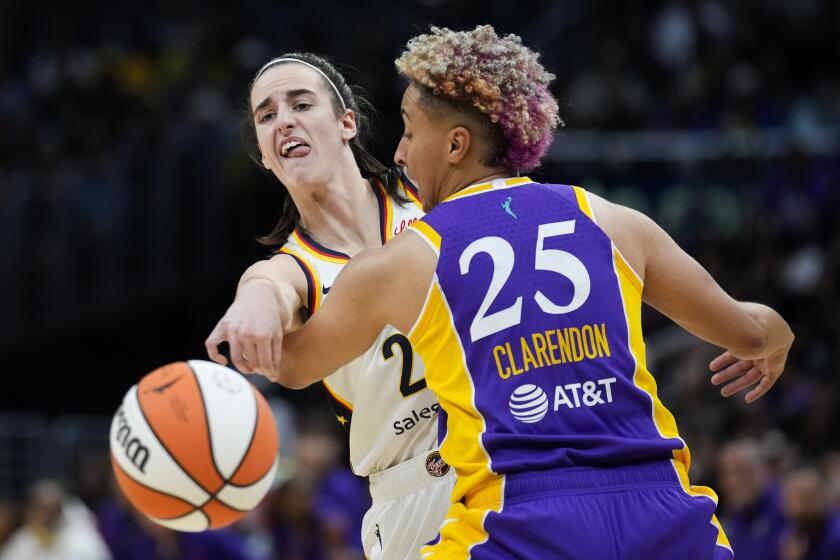 Indiana Fever guard Caitlin Clark (22) passes against Los Angeles Sparks guard Layshia Clarendon.