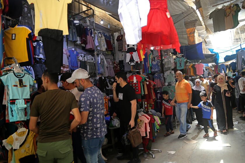 Iraqis buy clothes in preparation for the Muslim holiday of Eid al-Fitr, which marks the end of the holy fasting month of Ramadan, at the Shorjah market in central Baghdad, Iraq, Tuesday, May 11, 2021. (AP Photo/Hadi Mizban)