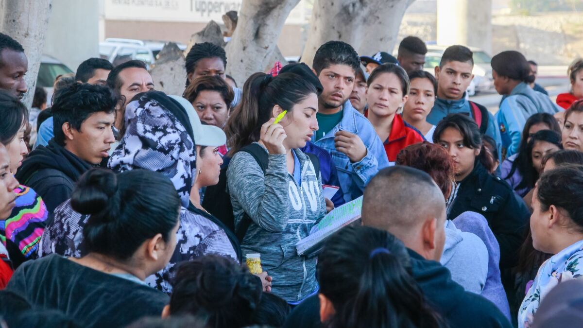 Familes in Tijuana preparing to petition for asylum at the San Ysidro Port of Entry on Wednesday check their number on a wait list that is maintained by the migrants themselves.