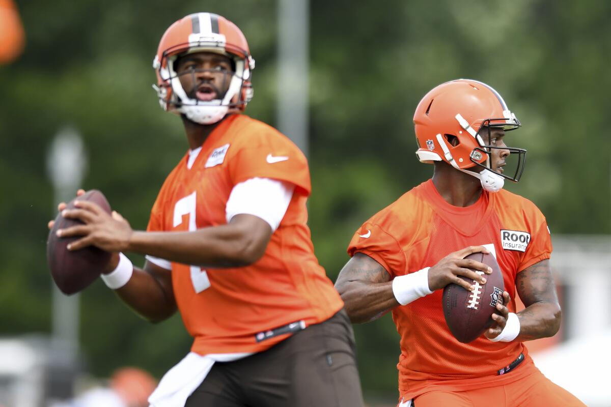 Cleveland Browns quarterbacks Deshaun Watson, right, and Jacoby Brissett look to pass during the NFL football team's training camp, Monday, Aug. 1, 2022, in Berea, Ohio. (AP Photo/Nick Cammett)