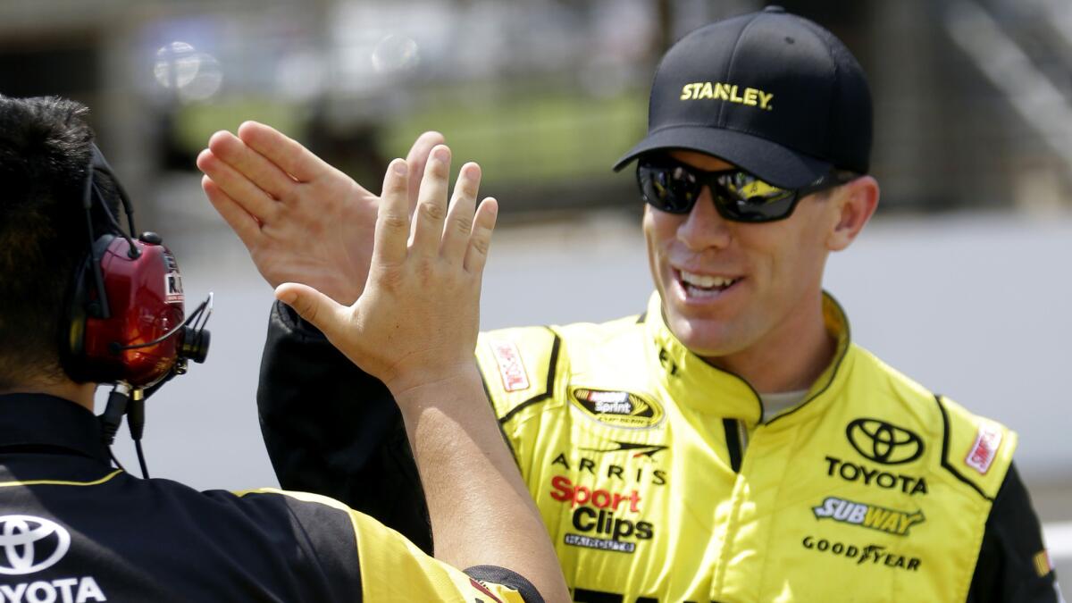 NASCAR driver Carl Edwards celebrates with a crew member Saturday after winning the pole for the Sprint Cup Series Brickyard 400.