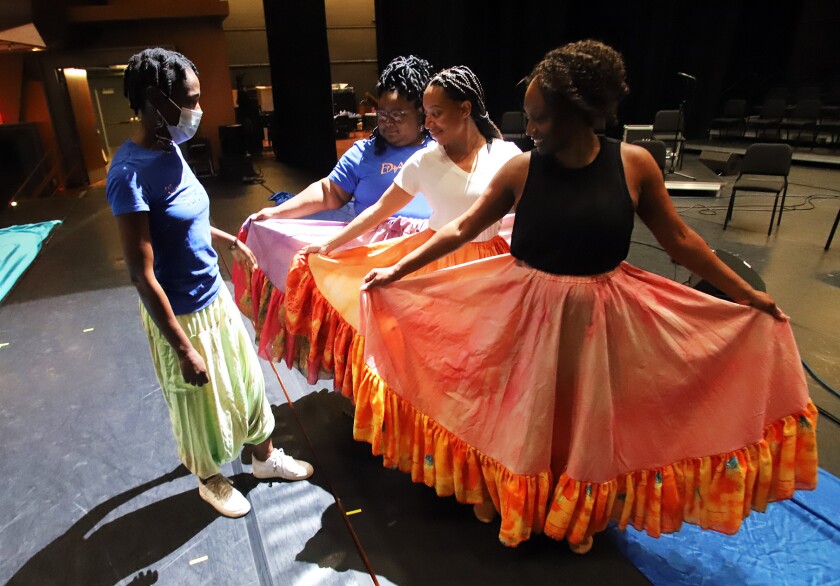 Imani Harris, the choreographer for Gospel Voices of OC, left, rehearses a scene with dancers.