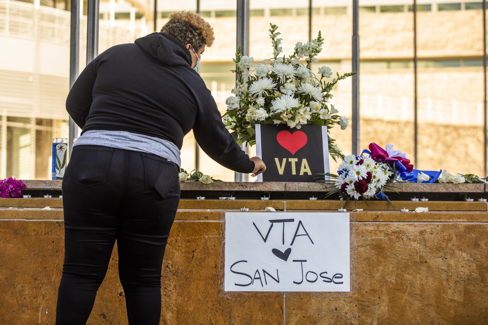 A person approaches flowers on a flat surface.