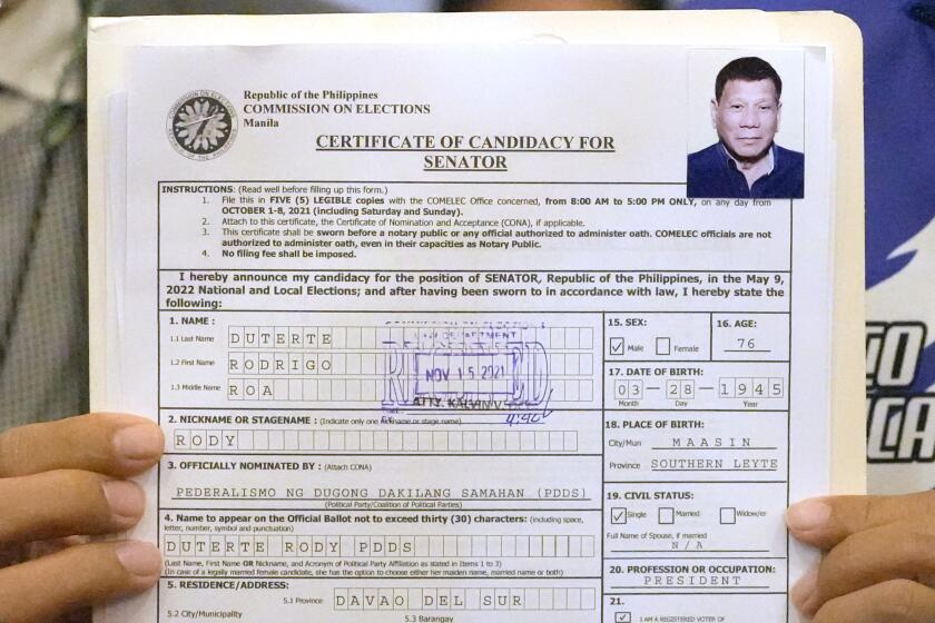 A representative of Philippine President Rodrigo Duterte holds his Certificate of Candidacy for Senator at the Commission on Elections in Manila, Philippines,Monday, Nov. 15, 2021. Duterte filed his candidacy Monday for a Senate seat in next year's elections, walking back on his announcement that he would retire from politics when his term ends and prompting human rights activists to press allegations that he would do anything to cling to power to evade accountability for his deadly anti-drugs crackdown. (AP Photo/Aaron Favila)