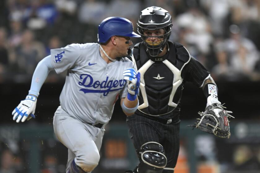 Los Angeles Dodgers' Miguel Rojas (11) is tagged out by Chicago White Sox catcher Korey Lee.