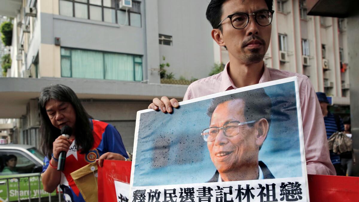 Pro-democracy protesters hold a picture of Wukan village leader Lin Zuluan during a demonstration Sept. 9. Lin was detained by Chinese authorities as he planned to lead protests over land seizures.