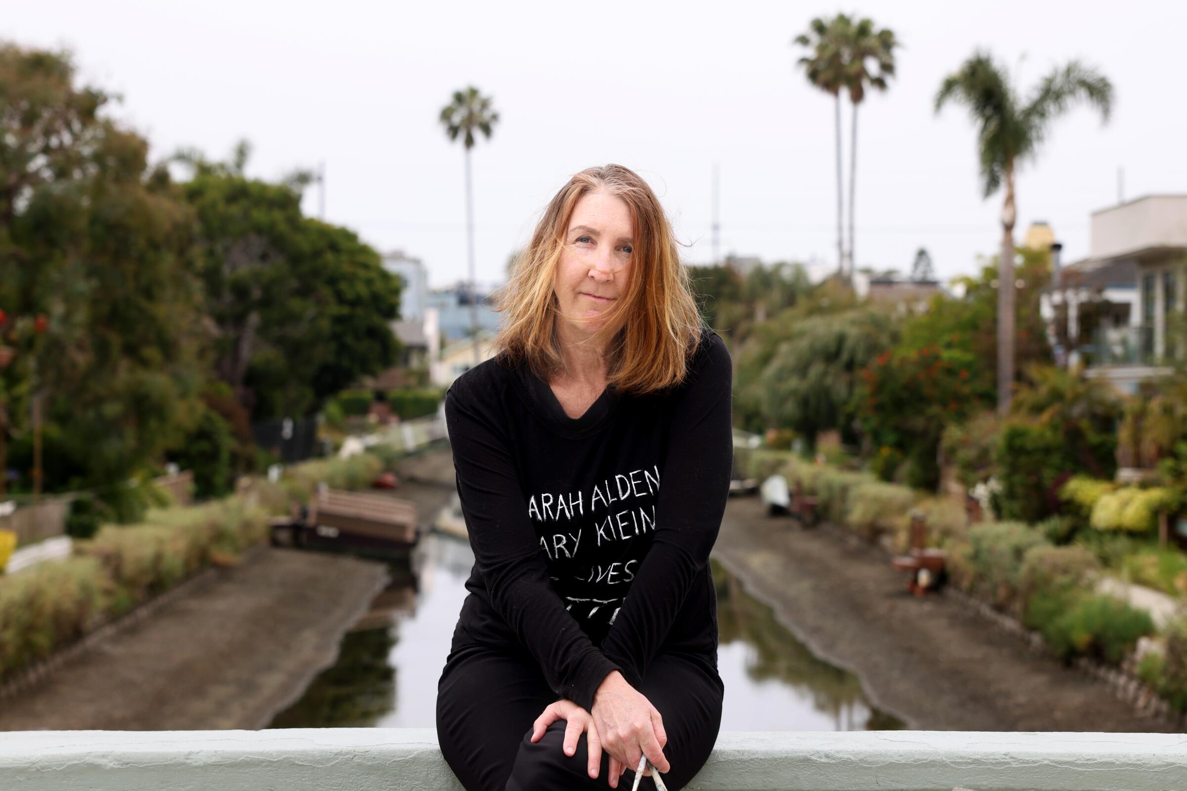 Venice resident Mary Klein sits atop a bridge over the Venice Canals where she was attacked in April.