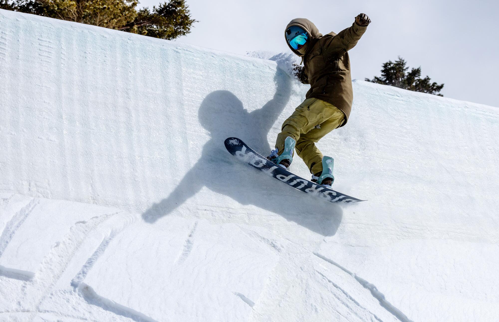  A snowboarder scrapes the top edge of a halfpipe.
