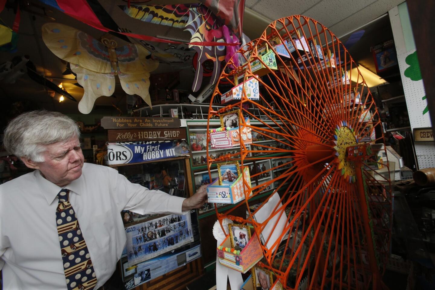 Gregory Kelly, who creates scale models of attractions out of scraps, spins a ferris wheel he made at Kelly's Hobby Shop in Old Town Tustin on March 24, 2014.