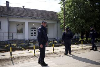 Police officers outside a schoolyard in the village of Dubona, Serbia, on Friday.