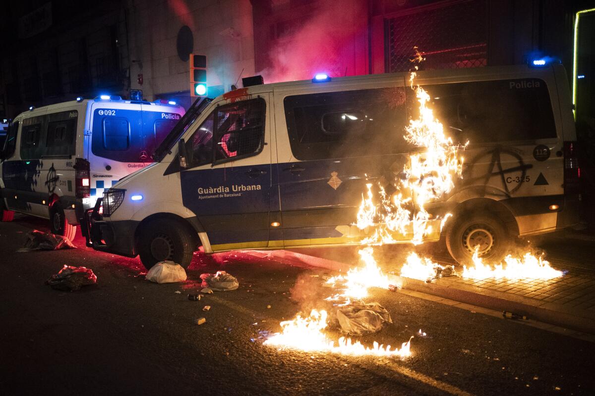 A police van is set on fire as protestors throw molotov cocktails at police during clashes following a protest condemning the arrest of rap singer Pablo Hasél in Barcelona, Spain, Saturday, Feb. 27, 2021. After a few days of calm, protests have again turned violent in Barcelona as supporters for a jailed Spanish rapper went back to the streets. (AP Photo/Emilio Morenatti)