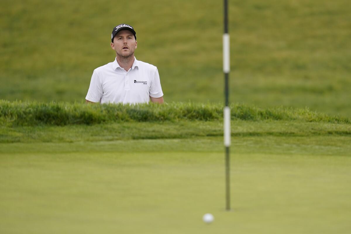 First-round leader Russell Henley watches his shot on the first green roll wide of the cup at the U.S. Open.