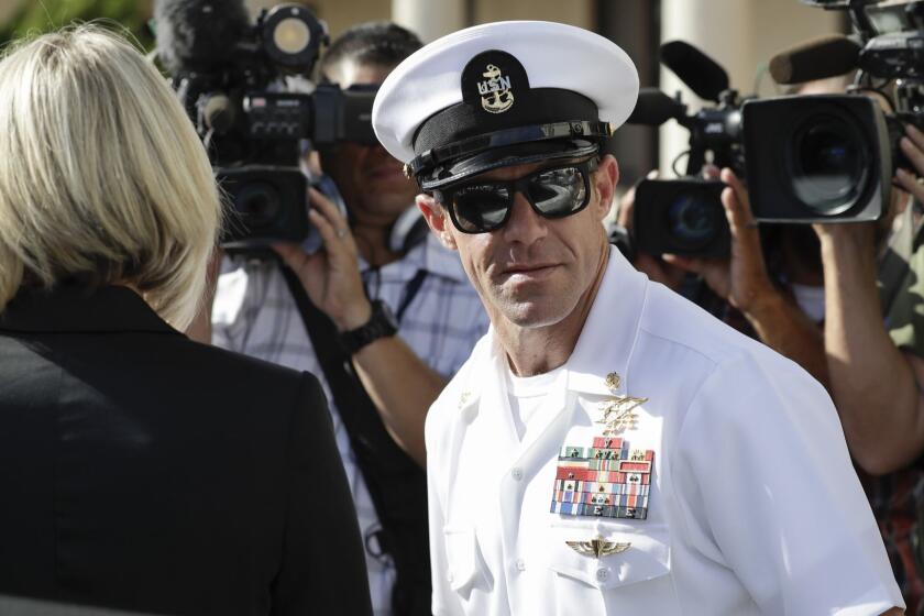 Navy Special Operations Chief Edward Gallagher, right, and his wife, Andrea Gallagher leave a military court on Naval Base San Diego, Tuesday, July 2, 2019, in San Diego. A military jury acquitted a decorated Navy SEAL of premeditated murder Tuesday in the killing of a wounded Islamic State captive under his care in Iraq in 2017. (AP Photo/Gregory Bull)