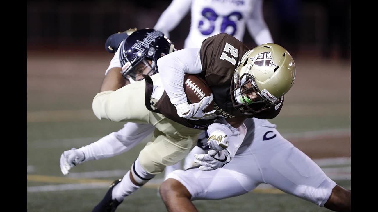 St. Francis High School football player #21 Kevin Armstead is tackled by a Cathedral High School player in home game at Friedman Field in La Cañada Flintridge on Friday, Nov. 3, 2017.