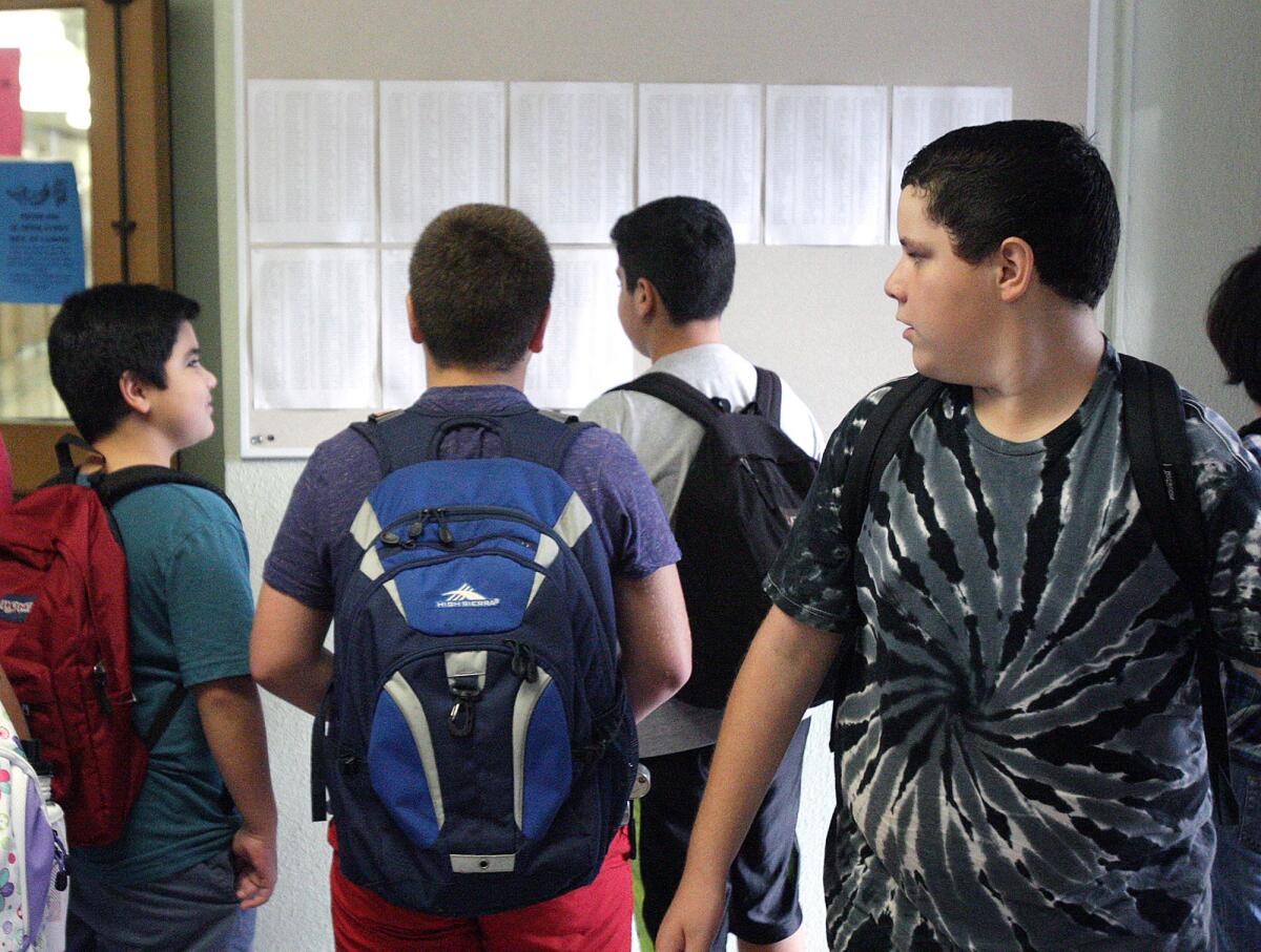 Students congregate at a bulletin board with room assignments on the first day of school at John Muir Middle School in Burbank on August 17, 2015.
