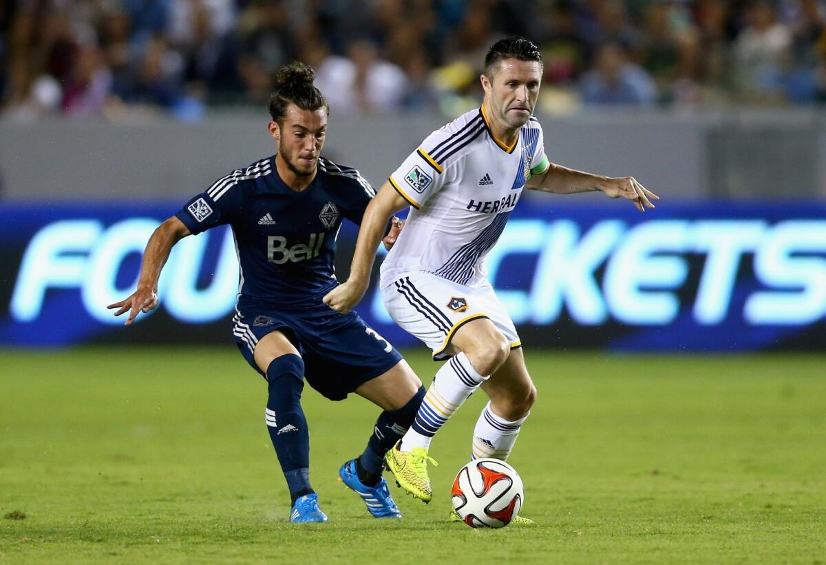 The Galaxy's Robbie Keane is pursued by Vancouver's Russell Teibert during the second half of a match on Aug. 23. The Galaxy beat the White Caps, 2-0.