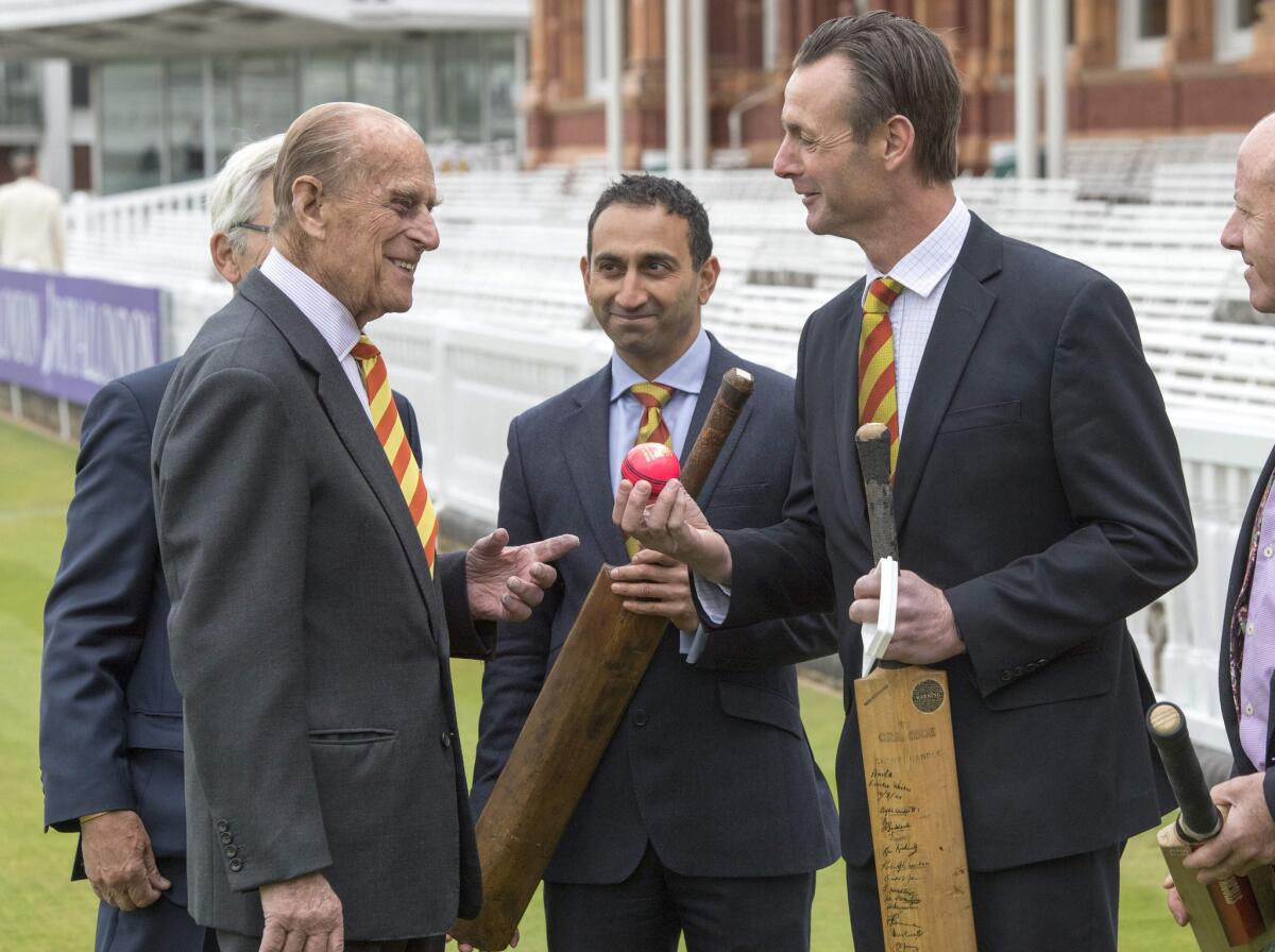 Prince Philip, visiting the Marylebone Cricket Club on May 3, is shown a pink ball used in day/night matches by former cricketer John Stephenson.