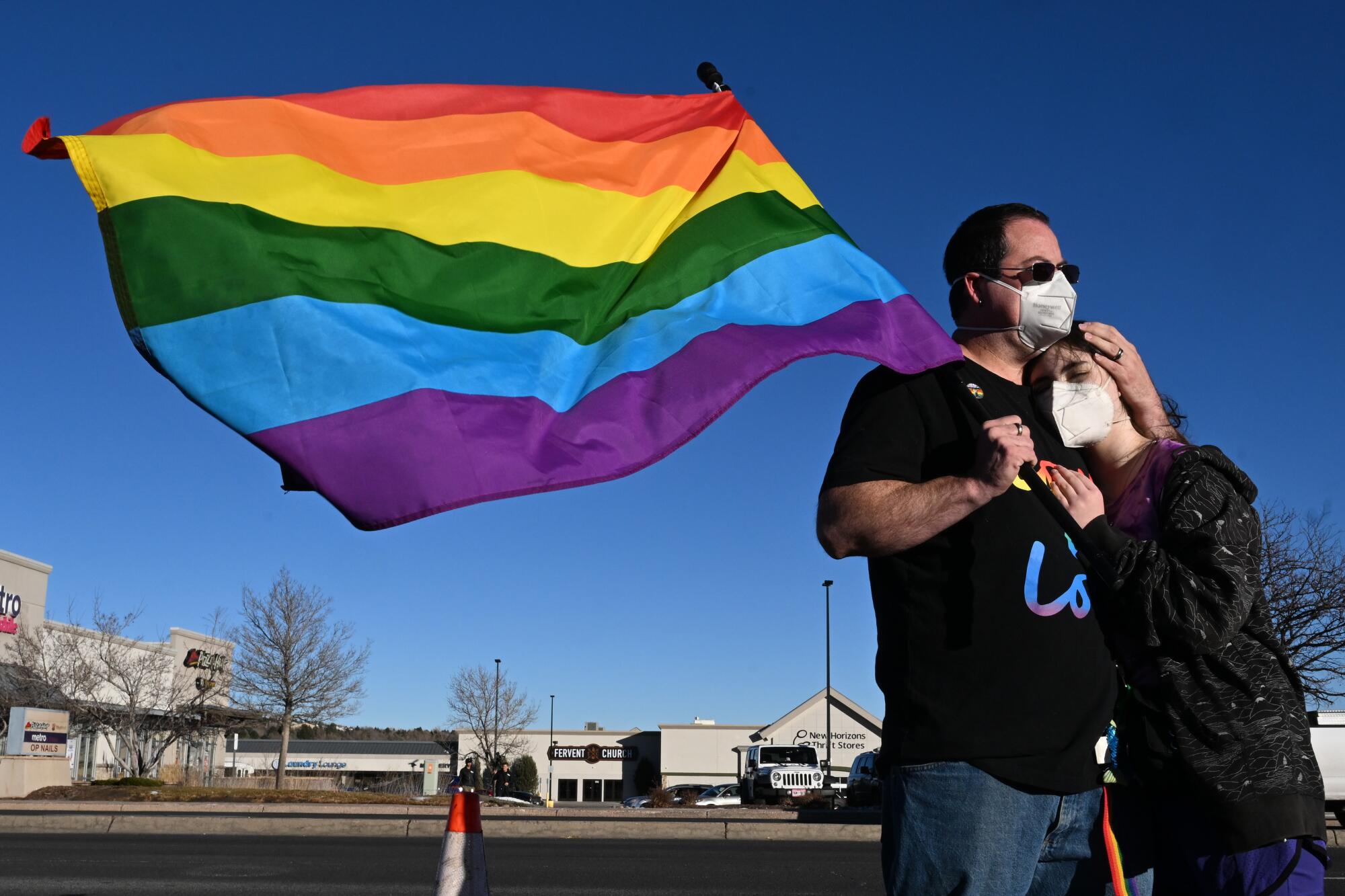 A man, left, and his daughter hug while paying their respects at a makeshift memorial near Club Q in Colorado Springs, Colo.