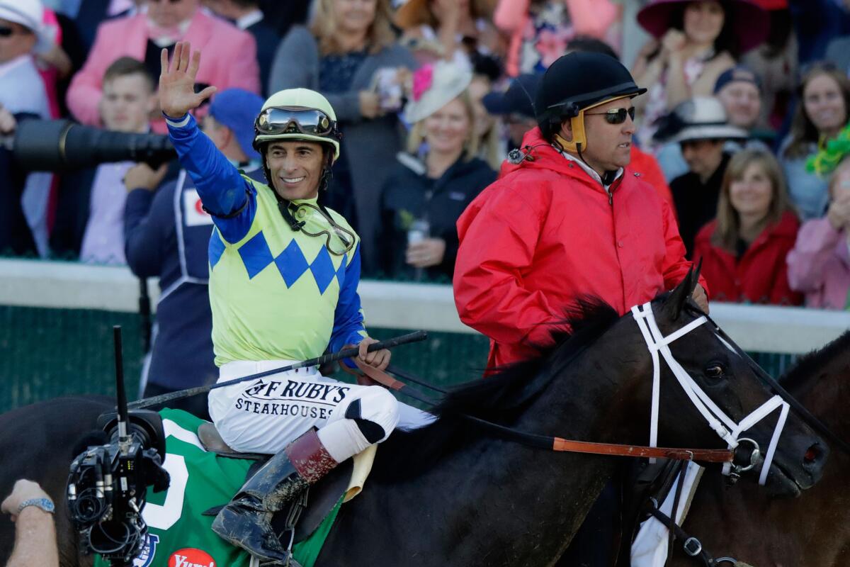 Jockey John Velazquez acknowledges fans' cheers after riding Always Dreaming to victory in the 143rd Kentucky Derby.