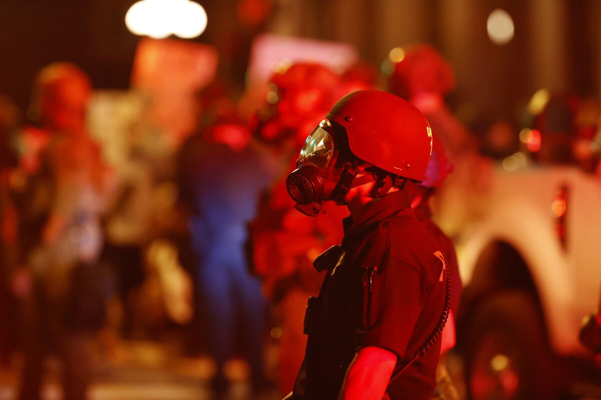 A Denver police officer wears a gas mask.