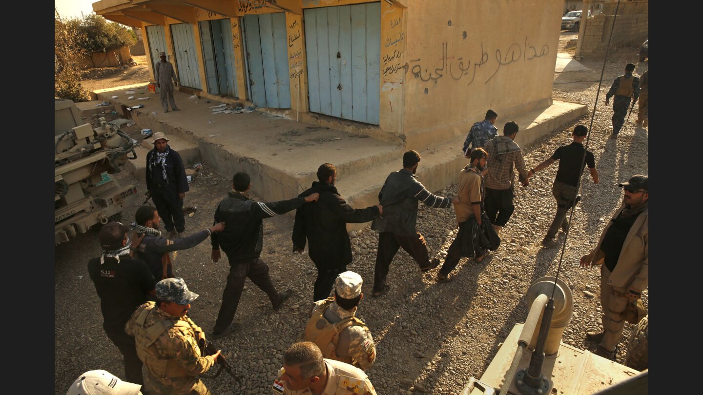 In the town of Salhiya, members of the Iraqi Army and Iraqi police detain and question men who were coming from the direction of Mosul.