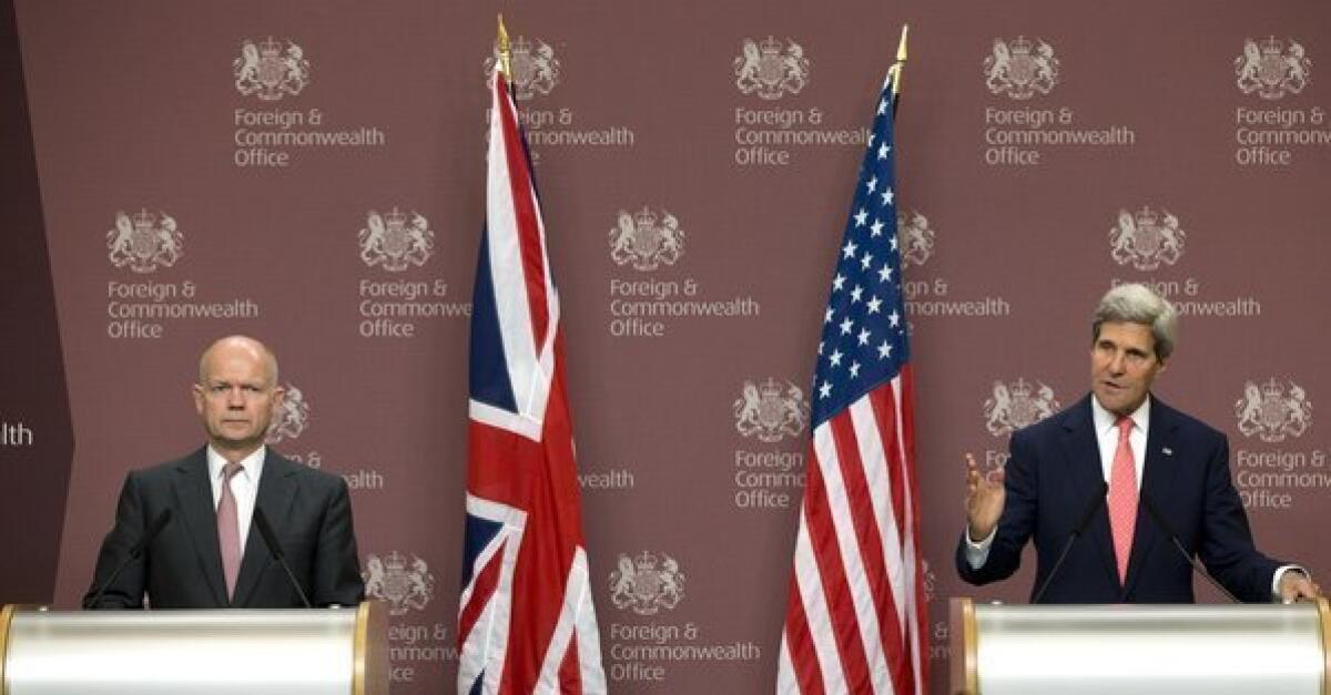 Britain Foreign Secretary William Hague, left, looks on as Secretary of State John F. Kerry speaks at a news conference in London on Monday.