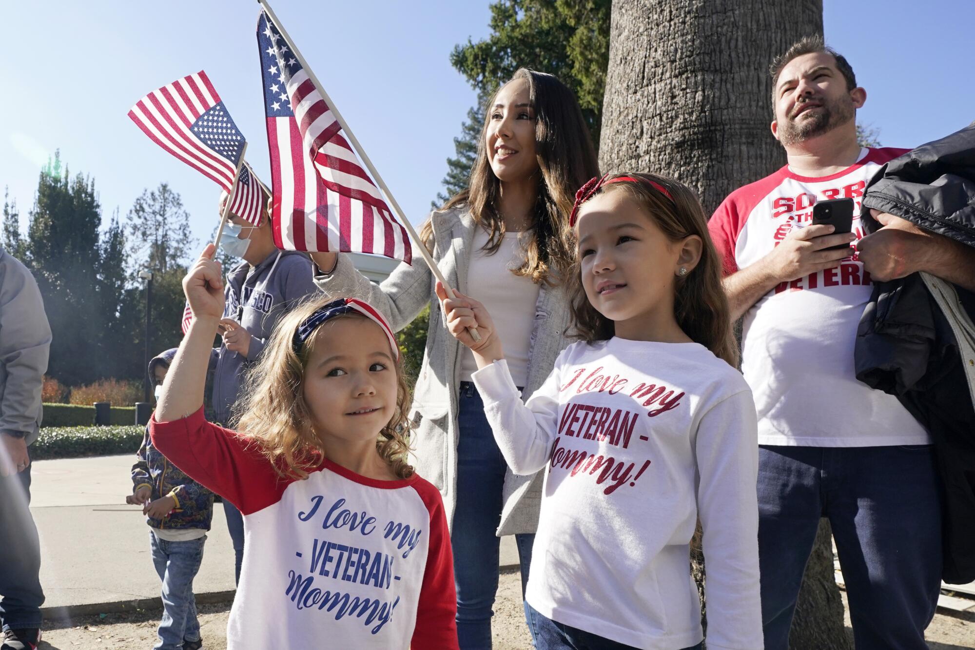 A family waves U.S. flags at a parade
