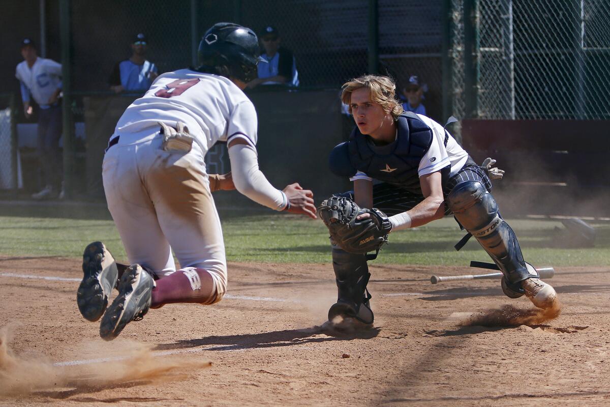 Corona del Mar catcher Dillon Lane, right, makes the tag on Laguna Beach's Noah Neufeld, left, at home plate.