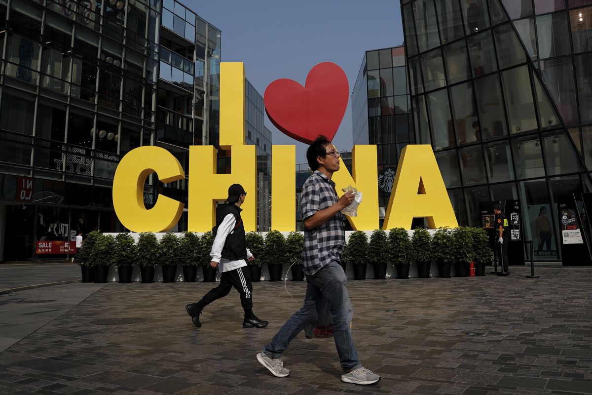 Shoppers walk through a mall in Beijing in September. Chinese experts and news media joined government officials in saying the preliminary trade deal with the U.S. would reduce uncertainty for companies, at least in the short term.