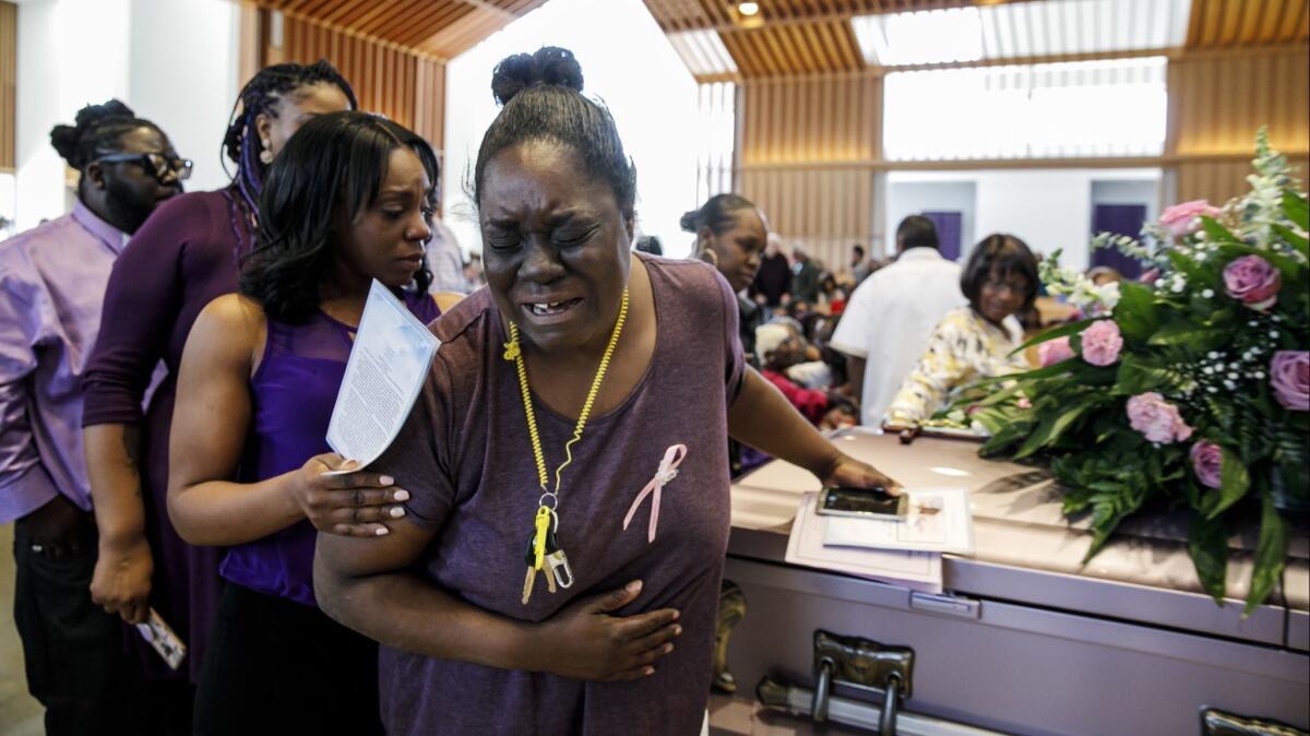 Asunoya Sanni walks away in tears Monday after touching the casket of Trinity Love Jones during a community memorial service for the girl at St. John Vianney Catholic Church in Hacienda Heights.