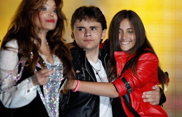 LaToya Jackson (L), and Michael Jackson's children Prince Michael Joseph Jackson Jr.(C) and Paris-Michael Katherine Jackson (R) react on stage at the end of the 'Michael Forever' tribute concert at the Millennium Stadium in Cardiff, Wales.
