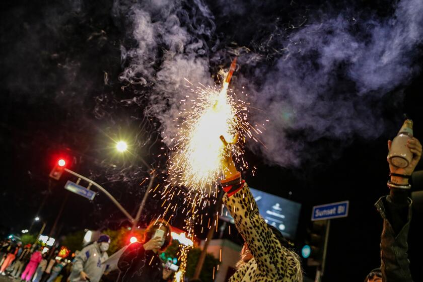 Los Angeles, CA, Saturday, November 7, 2020 - Erica Clum sets off fireworks as celebrations on Sunset Blvd. continue after Joe Biden is announced as the President-elect of the United States. (Robert Gauthier/ Los Angeles Times)