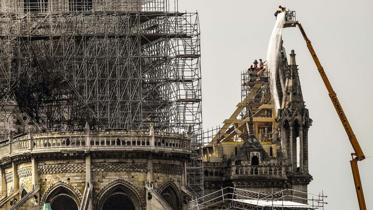 Firefighters continue to hose down parts of Notre Dame Cathedral on Wednesday, three days after a fire devastated the renowned Paris landmark.