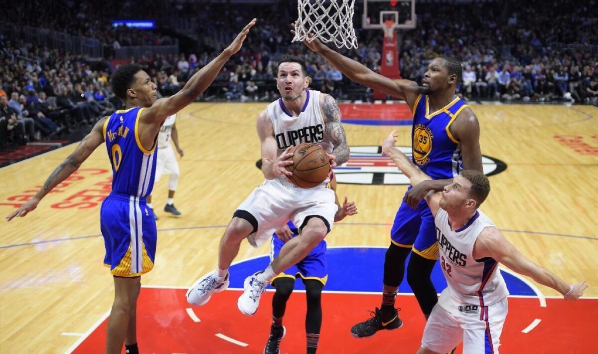Clippers guard J.J. Redick goes up for a shot between Warriors guard Patrick McCaw, left, and forward Kevin Durant during the second half on Feb. 2.