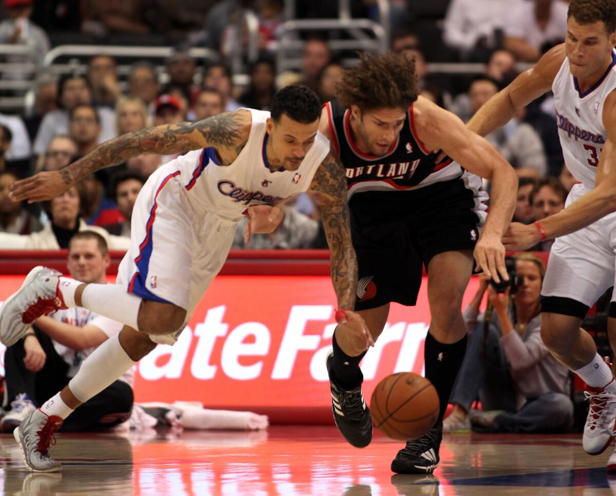 Robin Lopez, right, and Matt Barnes chase a loose ball during a game between the Clippers and Portland Trail Blazers in 2014.