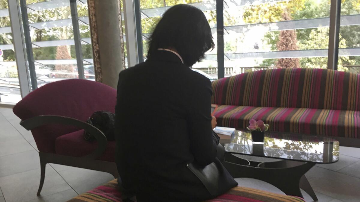 Grace Meng, the wife of missing Interpol President Meng Hongwei, who does not want her face shown, consults her mobile phone recently in the lobby of a hotel in Lyon, France, where the police agency is based.