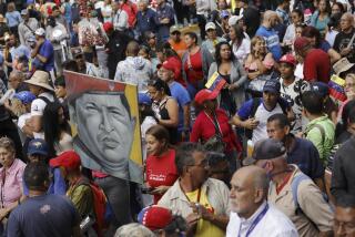 Government supporters hold a painting depicting the late Venezuelan President Hugo Chavez, during an event marking the anniversary of the 1958 coup that overthrew dictator Marcos Perez Jimenez, in Caracas, Venezuela, Tuesday, Jan. 23, 2024. (AP Photo/Jesus Vargas)