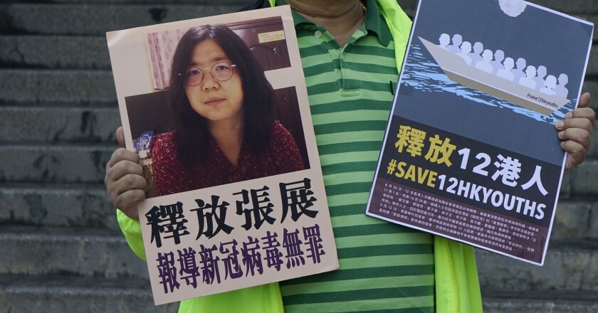A pro-democracy activist holds placards with the picture of Zhang Zhan in Hong Kong.