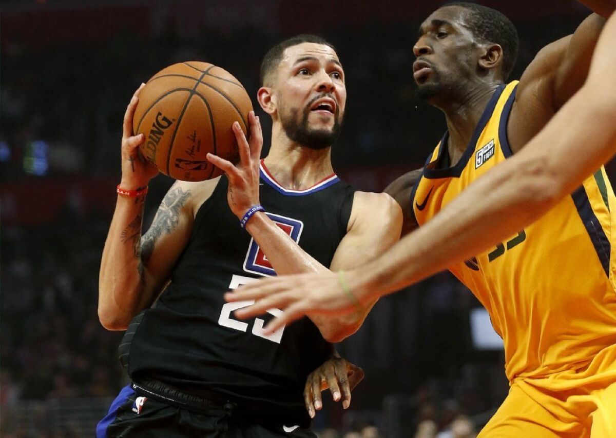 Clippers guard Austin Rivers, left, drives against Jazz center Ekpe Udoh during the first half of a game Nov. 30 at Staples Center.