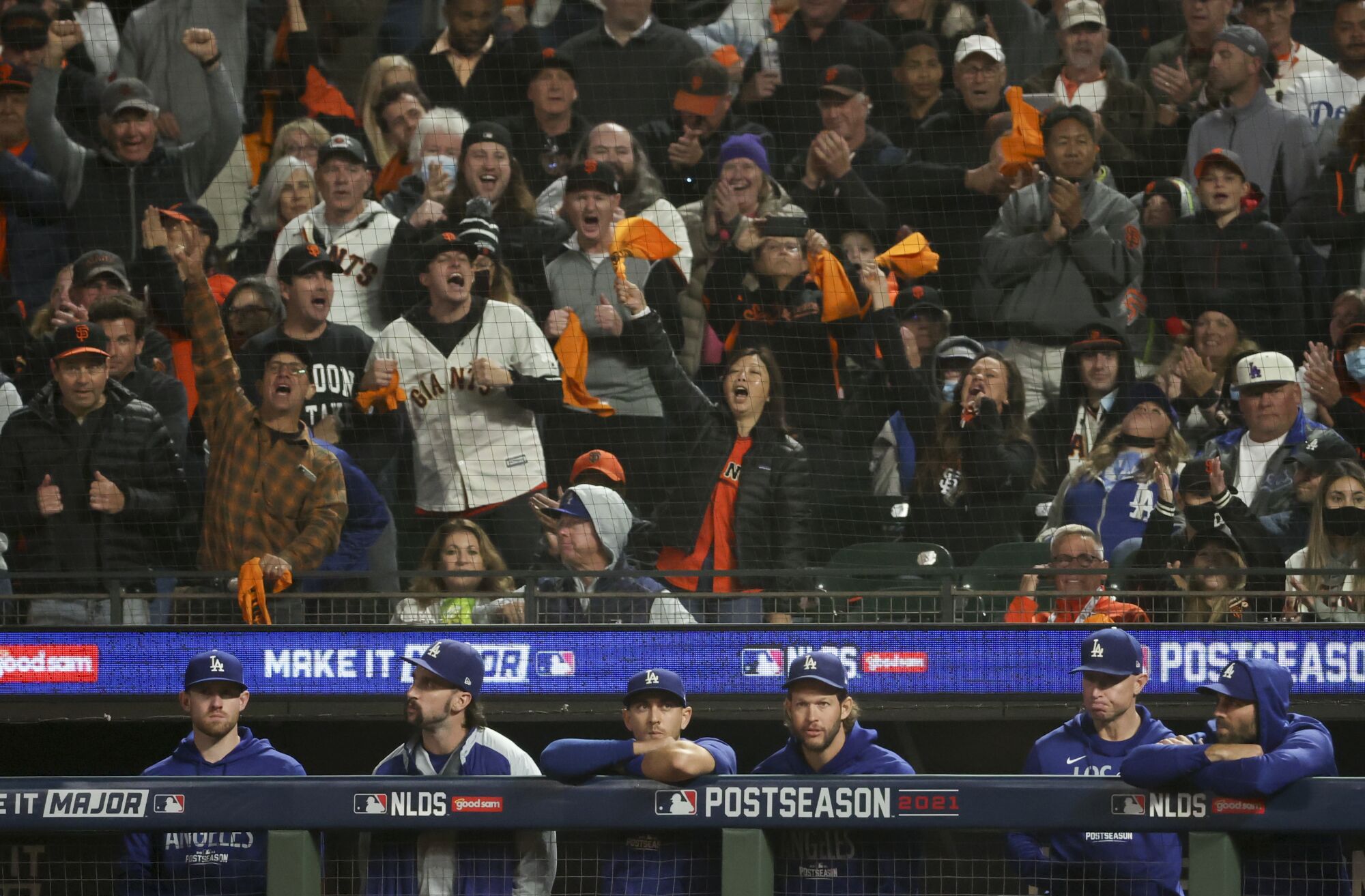 San Francisco Giants fans cheer behind the Los Angeles Dodgers bench after a strikeout by AJ Pollock